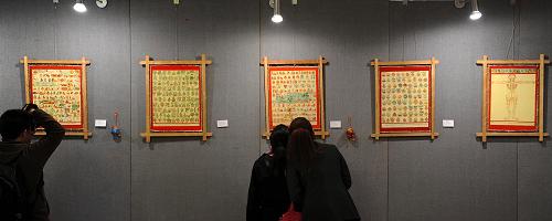 Visitors watch enthusiastically  the masterpieces of Thangka exhibited at the Cultural Palace of Nationalities of Beijing, photo from Xinhua, November 16.