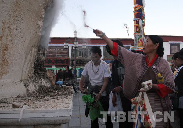 Buddhist believers burn mulberry branches in the incense-burner in front of the Jokhang Temple on June 15.