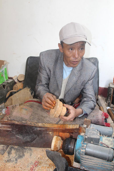 Photo shows a Menba craftsman works on a wooden bowl.[Photo/China Tibet Online]