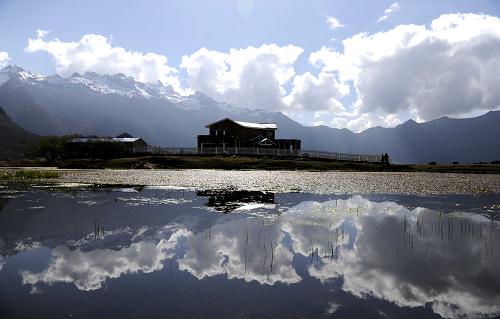Viewing Platform glasses itself in the pond in Nai Village of Gyirong Township [Photo/Xinhua]