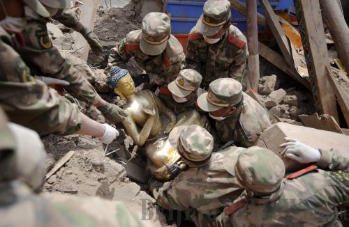 Soldiers of the Chinese People's Armed Police Force dig out a Buddhist statue from rubble at the Thrangu Monastery in Yushu Tibetan Autonomous Prefecture in northwest China's Qinghai Province on April 19, 2010