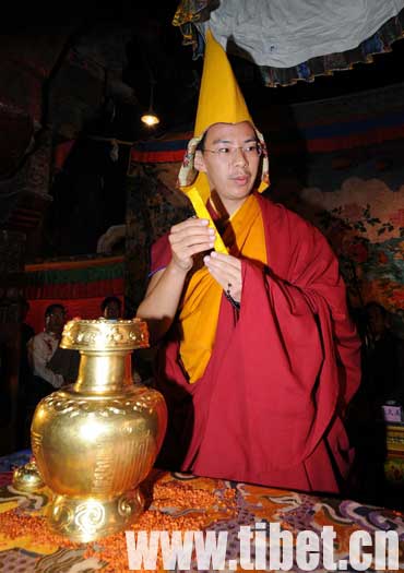 The 11th Panchen Lama Erdini Gyaincain Norbu, member of the Chinese People's Political Consultative Conference as well as Vice Chairman of the Buddhist Association of China, draw lots from a gold urn at the ceremony held at the Jokhang Temple of Lhasa to decide the reincarnation of the late 5th Dezhub Living Buddha