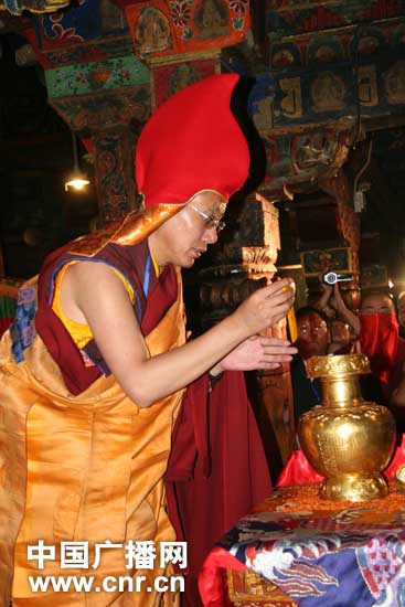 Dawa Tsering, chairman of the Buddhist Association of Lhoka and head of the search team for reincarnation boys, puts the slips bearing names of the candidates into the gold urn
