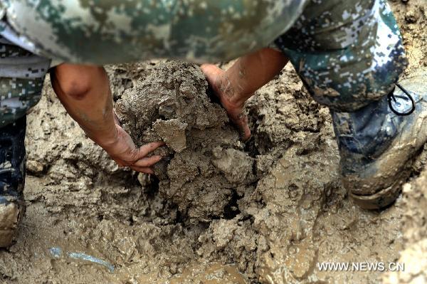 A soldiers works at landslide-hit Zhouqu County, Gannan Tibetan Autonomous Prefecture in northwest China's Gansu Province, Aug. 12, 2010