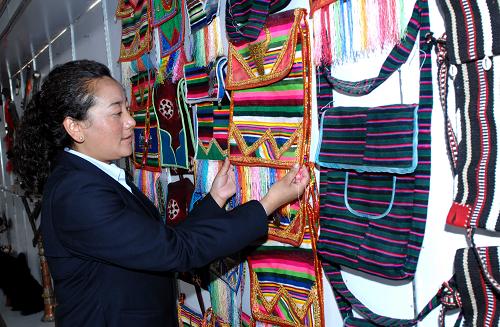 A salesman from Yamei National Arts and Crafts is introducing tourist souvenirs, photo from Xinhua, July 23.