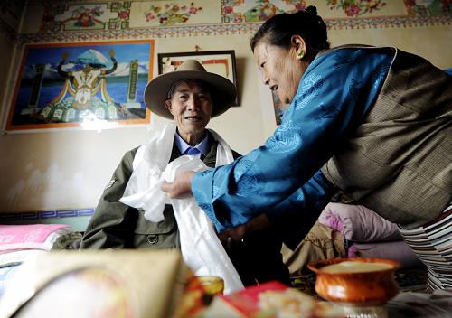 A Tibetan mom named Cangmula in the Lu Gu Villagers' Community of the Chengguan District of Lhasa, capital city of southwestern China's Tibet Autonomous Region, is presenting a white hada to her husband of Han nationality during the Mid-autumn Festival, which falls on September 22 this year, photo from Xinhua.