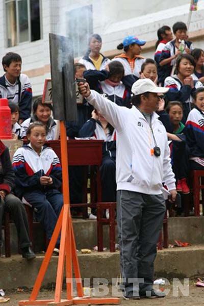 A referee fires the gun for runners at the starting line