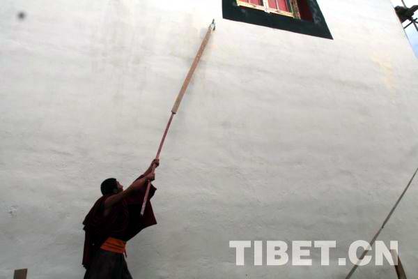 A monk  of Zogong Monastery, Chamdo Prefecture is busy with the maintenance work, photo from tibet.cn.
