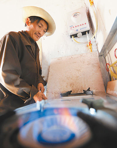 A local villager uses the methane-gas stove in Chamdo, southwest China's Tibet Autonomous Region.