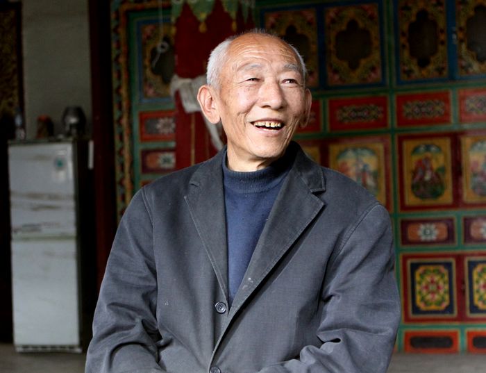 A retired head of township in Zuogong County of Chamdo Prefecture smiles in the living room of his home, photo from China Tibet Online.