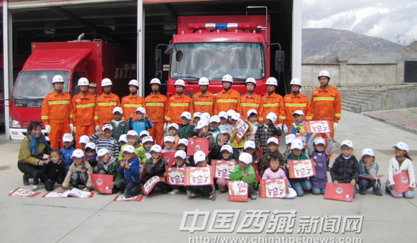 Children and teachers from Experimental Kindergarten of Lhasa take pictures with firemen.