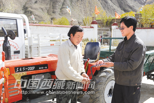 Photo shows He Desheng (L) donated a farm tractor to local needy people, Oct.25, 2010.