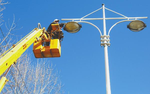Workers from Lhasa Public Facilities Maintenance Unit are repairing street lamps