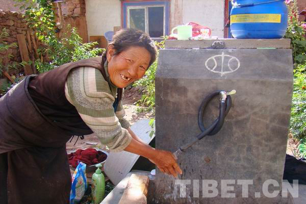 File photo from China Tibet Online shows a Tibetan mom in Bogong Village of Chagyab County in Chamdo Prefecture fetching water from a water faucet.