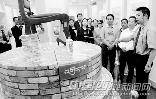 Photo shows the showroom of Lhasa Legal Education Center where money, wine bottle and high-heel shoes are displayed as the three legs of a falling chair.
