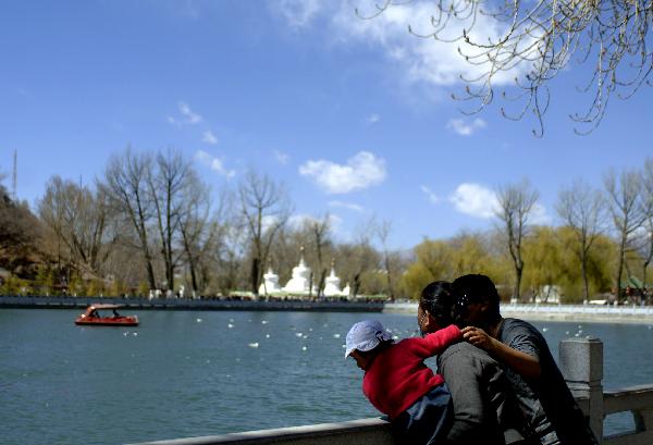 A couple with child play in Dragon King Lake Park in Lsasa, southwest China's Tibet Autonomous Region, April 3, 2011. Lhasa city is in a furious spring with the warming tempreture. Many people go outside to feel the breath of spring. [Photo/Xinhua]