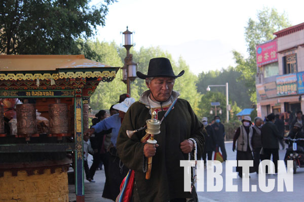 In the morning, prayer walkers track along the ritual walk passage outside the wall of the Potala Palace. [Photo/Tibet.cn]