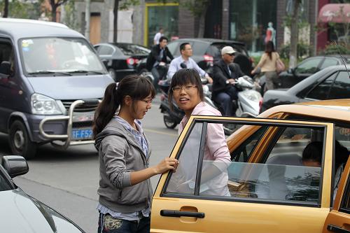 Yeshe Tsomo(L) takes the free taxies to participate in the annual college entrance examination, June 7. [Photo/Xinhua]