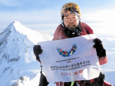 An Agricultural Bank of China Shenzhen Branch employee, Zhang Liang, places a Universiade flag on Mount Lhotse, the fourth highest mountain on Earth, on Thursday 26th May, 2011. Zhang has so far scaled the world's six highest mountains, all 8,000 meters above sea level. Mount Lhotse is located on the border between Tibet of China and Khumbu of Nepal. Courtesy of Zhang Liang.[Photo/China Daily]