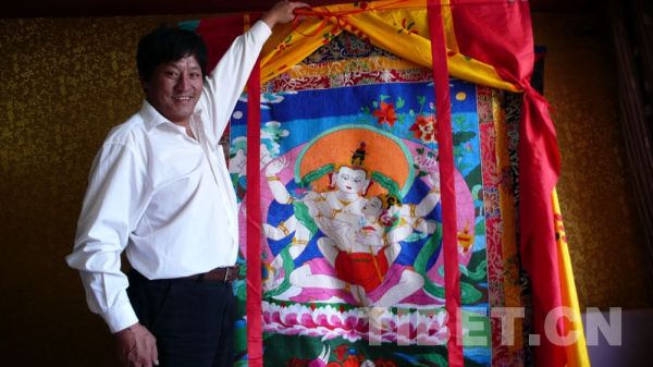 Losang Jigme of Khampa ethnic group shows his Thangka embroidery. [Photo/China Tibet Online]