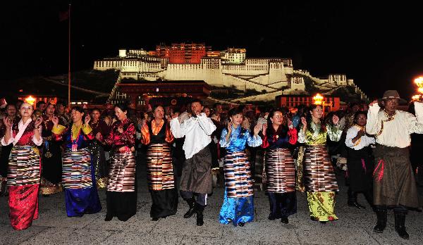 People dance during a firework show celebrating the 60th anniversary of Tibet's peaceful liberation at the Potala Palace Square in Lhasa, southwest China's Tibet Autonomous Region, July 19, 2011.[Photo/Xinhua]