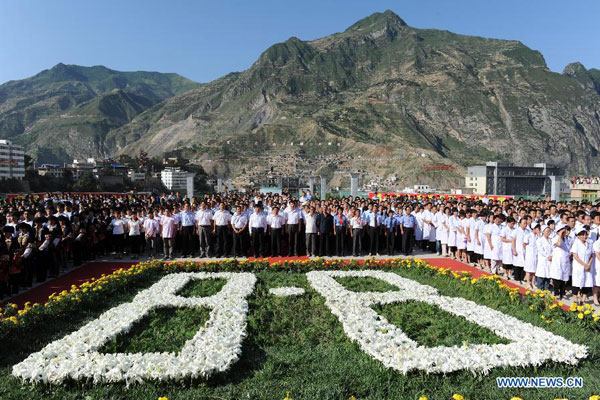 People attend the memorial ceremony for victims of the landslide occurred a year ago in Zhouqu, northwest China's Gansu Province, Aug. 8, 2011. The mudslide devastation in the county on Aug. 8, 2010 left more than 1,700 people dead or missing and some 60,000 houses damaged.[Photo/Xinhua]