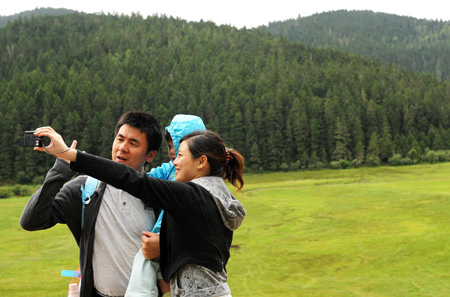 The picture taken on Oct. 13, 2009 shows tourists taking pictures at the Pudacuo National Park in Deqen Tibetan Autonomous Prefecture, southwest China's Yunnan Province.