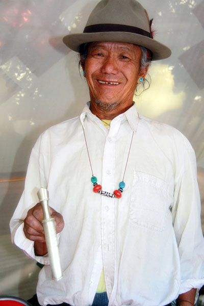 Tsedan Wanggye poses with a Tibetan knife at his booth at the Shigaste Culture Exhibition in Tibet on Aug 27, 2011.[Photo/chinadaily.com.cn]