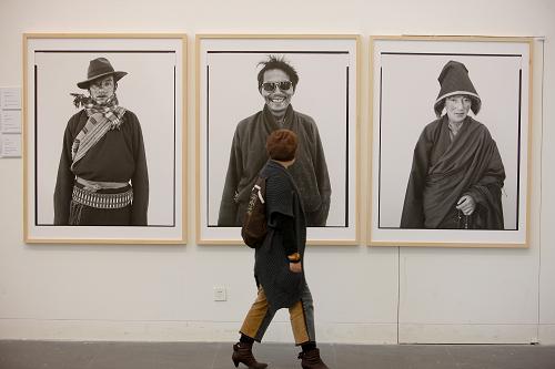 An audience is watching the photographic works in the exhibition on Oct. 13, 2011. [Photo/Li Xin]