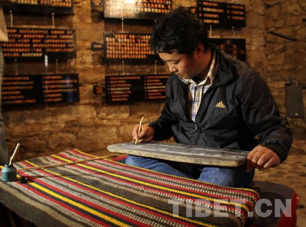 Many youngsters can still recall times when they sat with legs crossed and practiced writing on the "ChangShing" writing board. [Photo/Rao Chunyan]