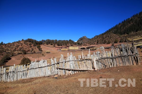 A small village nestles on a mountain slope. [Photo by Jiang Wanchuan/Tibet.cn]