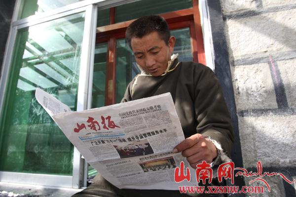 Tashi Tsering, Vice-principal of the school, reads newspaper. [Photo/XZSNW.com]