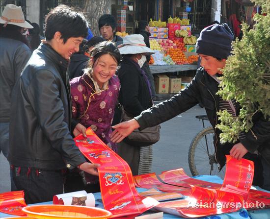 Tibetans buy New Year scrolls which symbolize happiness, prosperity and sweet love at a market in Lhasa, capital of Tibet, Feb 23, 2011. [Photo/Asianewsphoto]