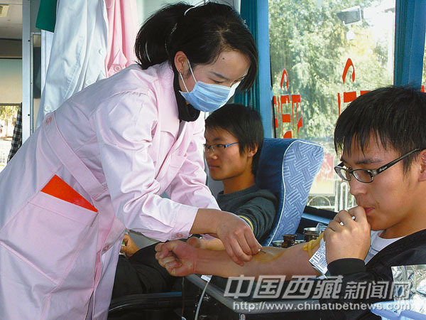 Two youths donate blood in a mobile blood-collecting vehicle. [File photo/Chinatibetnews.com]