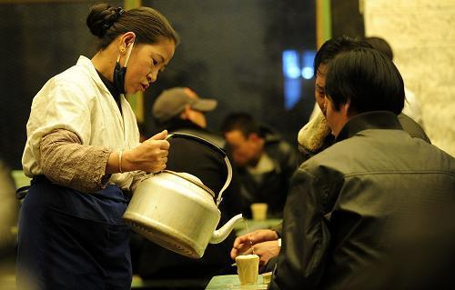 The waiter brings sweet tea for the customers in Guangming Kamqung Sweet Tea house. [Photo/Xinhua