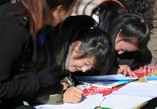 Students fill the forms to apply for jobsphoto taken on Dec.18 (Photo/Xinhuanet.cn)