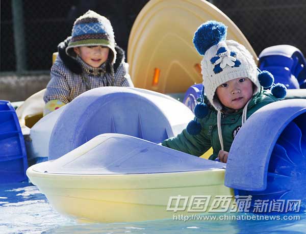 Two kids go boating in the lake of the amusement park. [Photo/Chinatibetnews.com]