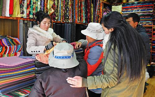 Consumers crowd into a traditional costume shop near the Barkhor Street, preparing new dresses for the upcoming Losar, Lhasa on Jan.9. Losar, the Tibetan new year falls on Feb.22 this year. [Photo/Xinhua]