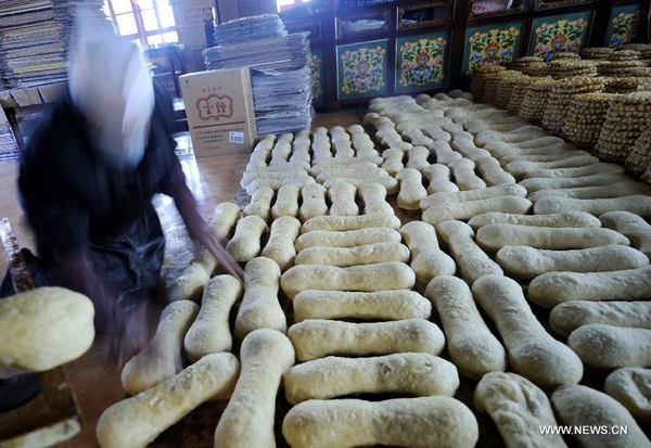 A shop assistant prepares special food for Tibetan New Year at a store in Lhasa, capital of southwest China's Tibet Autonomous Region, Feb. 6, 2012.