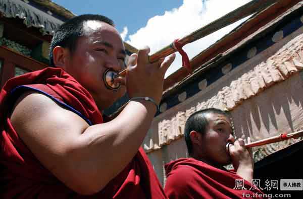 A pair of Tibetan monks blowing long horns in Samye Monastery [Photo/ ifeng.com]