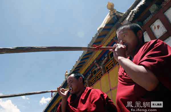 A pair of Tibetan monks blowing long horns in Samye Monastery [Photo/ ifeng.com]