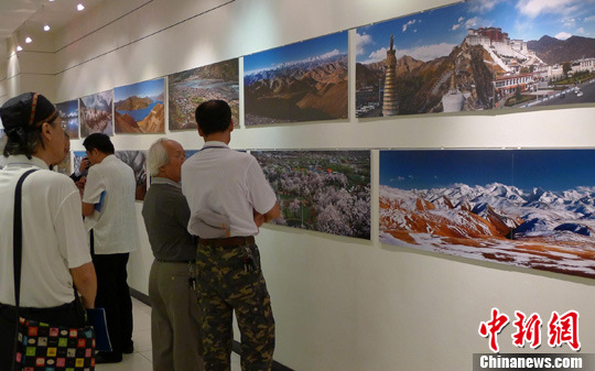 People were enjoying a photo exhibition titled Impression of Tibet in Taipei, capital of southeast China's Taiwan Province, June 10, 2012.[Photo/Chinanews.com]