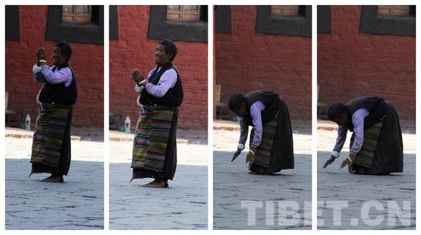 A eldery women in Tibetan costume is conducting a full-body prostration when going on a pilgrimate in the Sagya Monastery in Shigatse Prefecture, Tibet Autonomous Region. [Photo by Mirenda/China Tibet Online ]