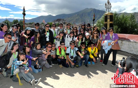 A delegation of Hong Kong youth took photo in front of the Jokhang Temple in downtown Lhasa, capital of southwest China’s Tibet Autonomous Region, July 5, 2012. [Photo/Chinanews.com]