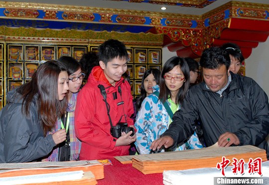 Youngsters from Hong Kong youth delegation watched Tibetan Buddhist scripture in Tibet University in Lhasa, July 5, 2012. [Photo/Chinanews.com]