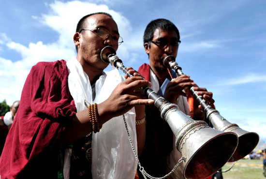 Monks perform during "Dama" (shooting arrows on horse) festival in Gyangze Township of southwest China's Tibet Autonomous Region, July 20, 2012.