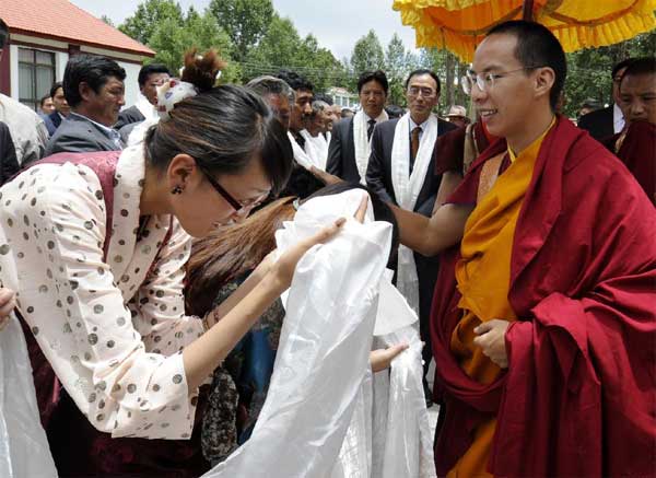 The 11th Panchen Lama, Bainqen Erdini Qoigyijabu (R), is greeted after arriving in Lhasa, capital of southwest China's Tibet Autonomous Region, July 23, 2012. The Panchen Lama began his Lhasa visit on Monday. The lama's visits have become an annual event in recent years. [Photo/Xinhua]
