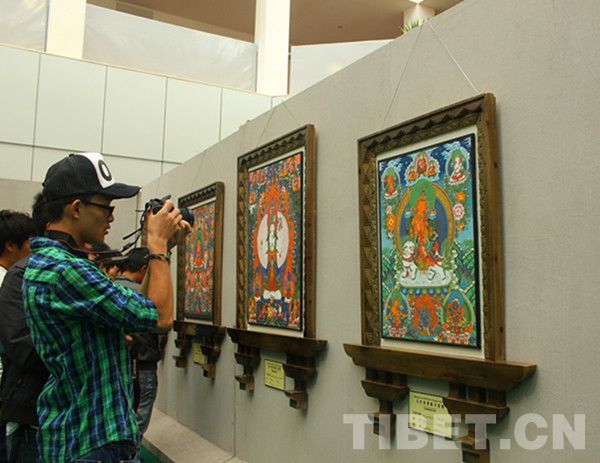 Local residents were watching the Thangka paintings displayed in a Manniang Thangka exhibition held in Lhasa, capital of southwest China's Tibet Autonomous Region, July 21. [Photo/China Tibet Online]