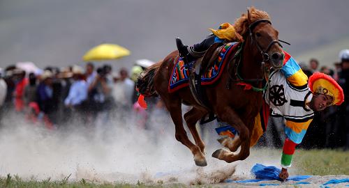 Equestrians present the horse riding skills for local Tibetans