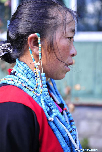 A woman of Lhoba ethnic group presents traditional costume in Nyingchi, southwest China's Tibet Autonomous Region on Oct. 30, 2012. The Lhoba costume has been listed as China's intangible cultural her